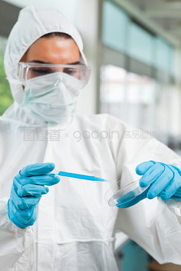 一个受保护的女学生在培养液D中滴下蓝色液体的肖像